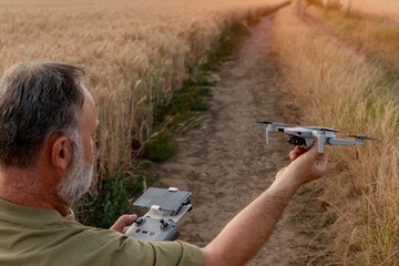 Bearded man using a drone with remote controller  making photos and videos,  having fun with new  technology trends