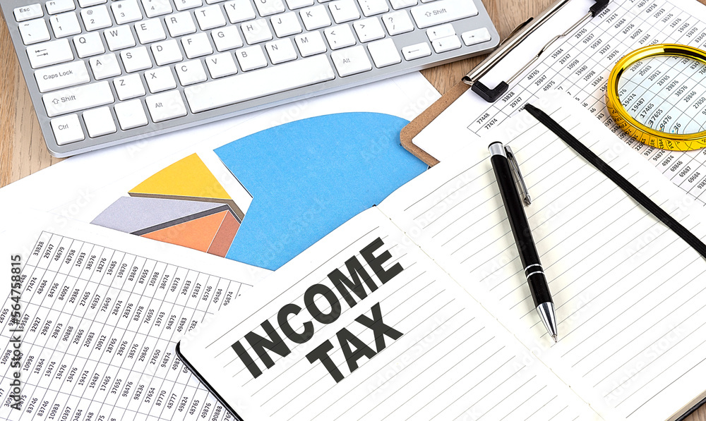 Poster income tax text on notebook with chart and keyboard