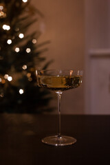 Champagne coup on dark background Christmas tree bokeh