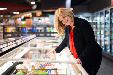 Frau im mittleren Alter beim Einkauf im Supermarkt 