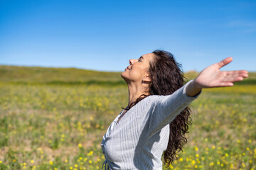 Excited Woman Raising Arms And Breathing Fresh Air In Yellow Field With Blue Sky Background...