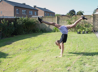 teenage girl doing acrobatic exercises on a green lawn, sport, generation z, 