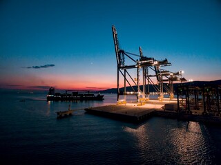 sunset drone photo of giant cranes in harbor