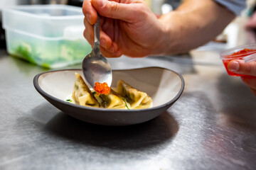 chefs hand making dumpling gyoza on kitchen