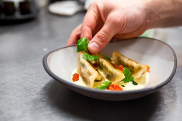 chefs hand making dumpling gyoza on kitchen