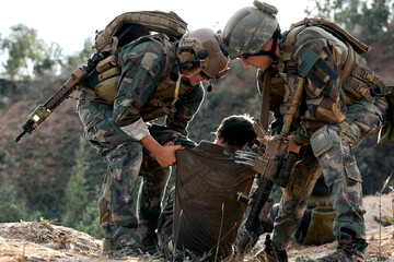 friendly fearless special forces soldiers help injured comrade during the rescue operation. war,...