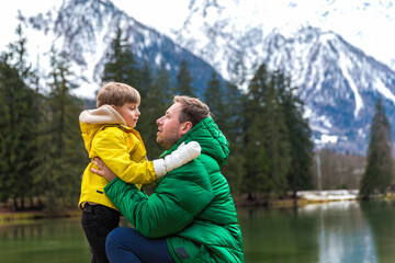 Father and son togethe having the holiday at Gaillands lake in Chamonix, french alps.Clouses green and yellow.