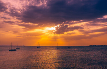 Sun starting to set behind clouds. View from the Promenade near Marina Rubicon in Playa Blanca,...