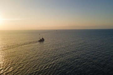 Fototapeta premium Fishing boat catching fish aerial view in the middle of the sea