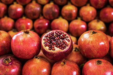 Closeup of pile pomegranates on market counter. Agricultural background. Healthy lifestyle, diet eating, organic vitamin