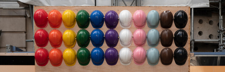 Colorful helmets as a protection for head for workers.  Construction industry and equipment for builder. Rainbow and lgbt at work. Banner.