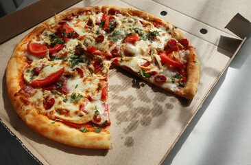Tasty pizza in paper box on table