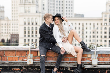 Fototapeta premium Beautiful happy young loving couple on a surprise date on a Saint Valentine's Day. Romantic modern wedding on the rooftop, summertime. Young man and beautiful girl. Newlyweds on honeymoon boho style