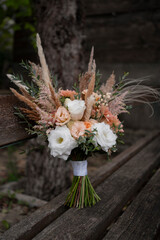 Beautiful wedding bouquet in vintage style. Boho bridal bouquet composed of lisianthus, pampas grass, roses and dried flowers. Wedding day.