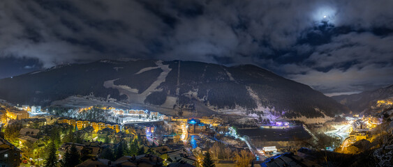 Panorama with El Tarter town. Hotels, resorts and residential buildings illuminated by street lights at night. Ski winter holidays, Andorra, Pyrenees