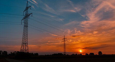Fototapeta na wymiar Beautiful sunset with a dramatic sky and overland high voltage lines near Tabertshausen, Bavaria, Germany