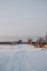 Fototapeta premium Snow-covered village streets and wooden