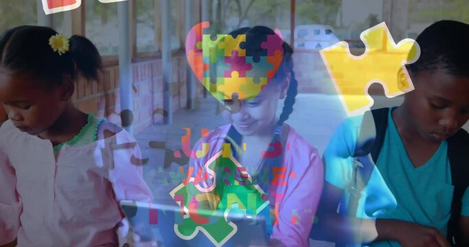 Animation of puzzle and autism awareness month text over diverse schoolchildren using tablet - Powered by Adobe