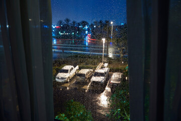 View of parking lot through window during rain at night, Los Angeles, California, USA