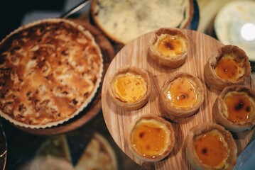 many different delicious desserts and orange pie on the table in the cafe