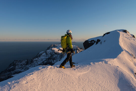 Female backpacker on mountain ridge of Mannen peak, Moskenesoya, Lofoten, Norway