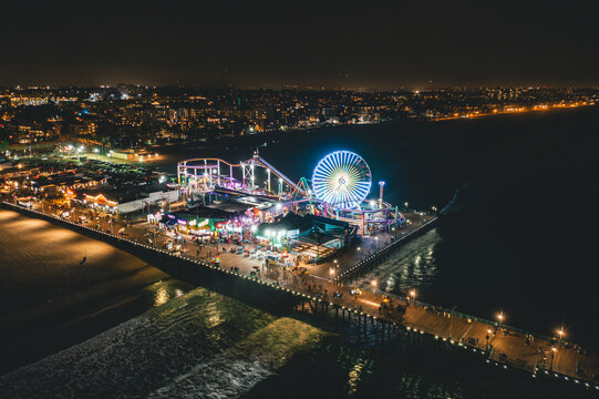 Circa November 2019: Santa Monica Pier at Night in super colourful lights from Aerial Drone perspective in Los Angeles, California