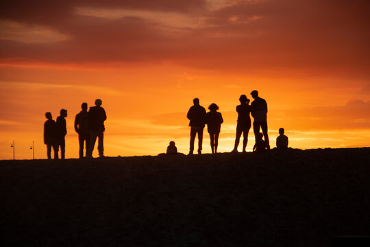 Group of people walking on the beach, enjoying the sunset in Venice Beach, Los Angeles, California, US.