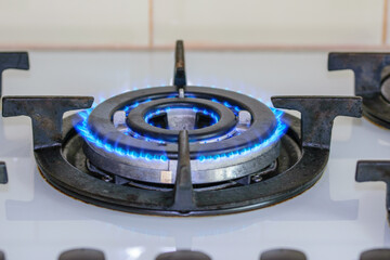 Zapalony palnik kuchenki gazowej z niebieskim płomieniem 