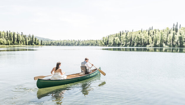 Bride and groom canoe at X-Y Lake in Talkeetna, Alaska.