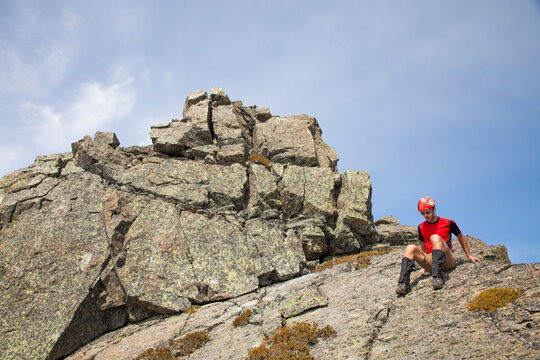 A climber down climbs a rocky summit.