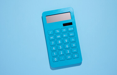 Blue plastic calculator on a blue background, top view