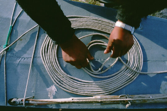An Inuit hunter carefully coils his harpoon rope.