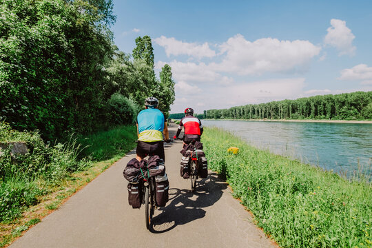 Two cyclists riding his bikes near to Rin River, Germany