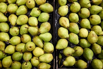 organic pears in a container at a market stall