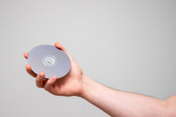 Hand holding a cd disc. Isolated on white with copy space.