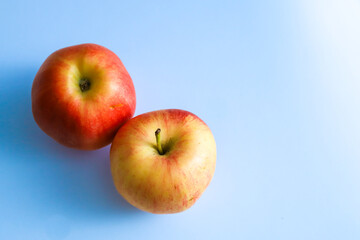 top view of two apples on blue background with copy space