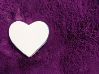 on soft purple fur lies a white heart