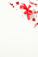 Valentine's Day vertical banner template with gift box, party streamers, confetti and candy.