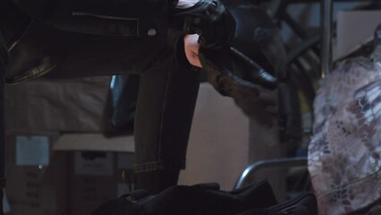 Robber in leather jacket  pulling on gloves stretching his hands