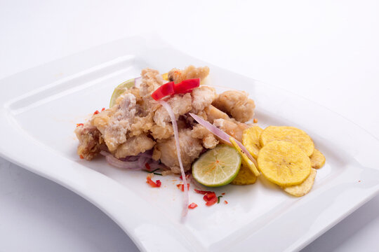 chicharon de pescado is ina peruvian food of fried marinated fish with onion aji and lemon.fried banana peruvian food