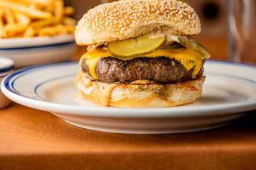 Hamburger. Bacon Cheeseburger. Classic traditional American bar, restaurant entree. Beef hamburger with Swiss and cheddar cheeses served with lettuce, tomato, onion and hand cut french fries. 