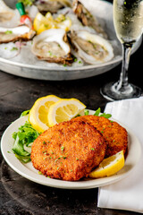Crab cake. Crab cake served with spicy rémoulade sauce on top of a mixed green salad. Jumbo crab meat mixed with garlic, onions, spices and fried in butter. Classic American restaurant appetizer.