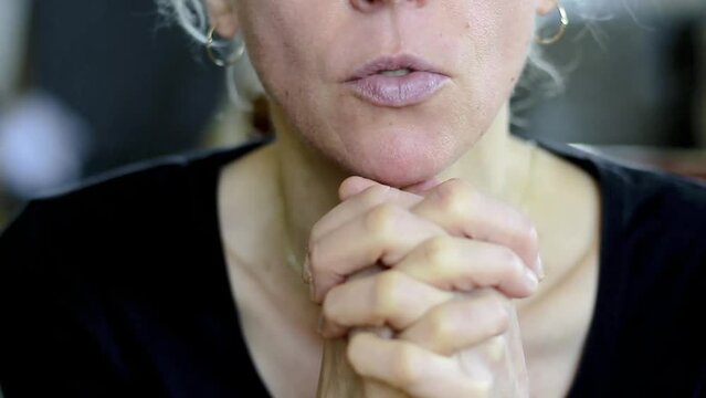 woman praying with hand over her face on grey background with people stock video