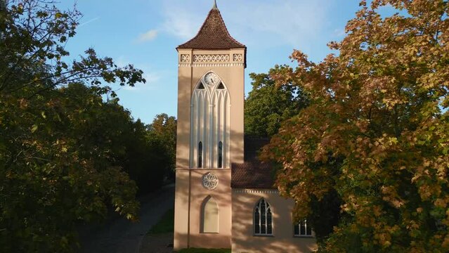 Majestic aerial view flight of Village church bell tower in Paretz raise up drone
in Brandenburg Havelland Germany summer evening 2022. High Quality 4k Cinematic footage