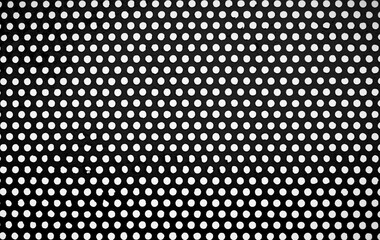 A perforated metal grunge background. circular perforated steel sheet is painted to prevent rust in gray