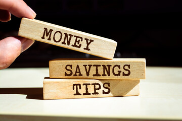 Wooden blocks with words 'Money Savings Tips'.