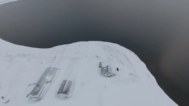View from above at farm covered in snow, winter Iceland. Tilt up 