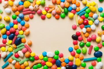 Mixed collection of colorful candy, on colored background. Flat lay, top view. frame of colorful chocolate coated candy