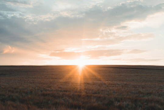 Scenic View Of Landscape Against Cloudy Sky During Sunset