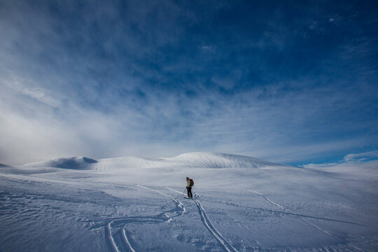 A skier descends a snow-covered peak in British Columbia while skiing the Spearhead Traverse near Whistler, Canada.